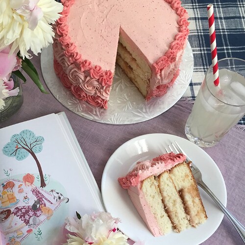 Photo of a pink cake with Genoese sponge, layers of rhubarb and custard and a strawberry swiss meringue buttercream