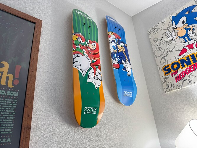 Two Sonic Adventure skate decks mounted vertically to the corner of a wall near the ceiling, one featuring Knuckles and the other of Sonic