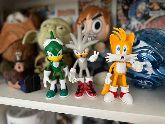 Bootleg figures of Jet, Silver and Tails standing on a shelf amongst other nerdy items